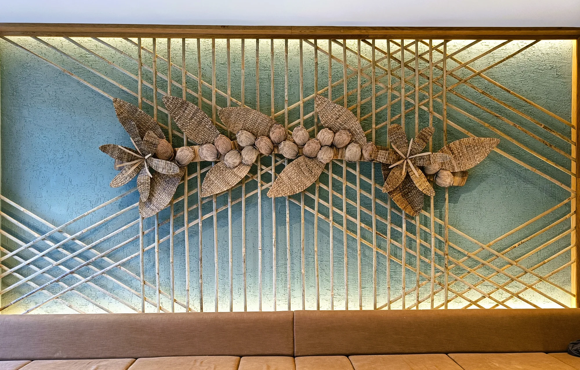 Woven cane and water hyacinth coffee-flower installation on a bamboo trellis wall at Starbucks GS Road, Guwahati